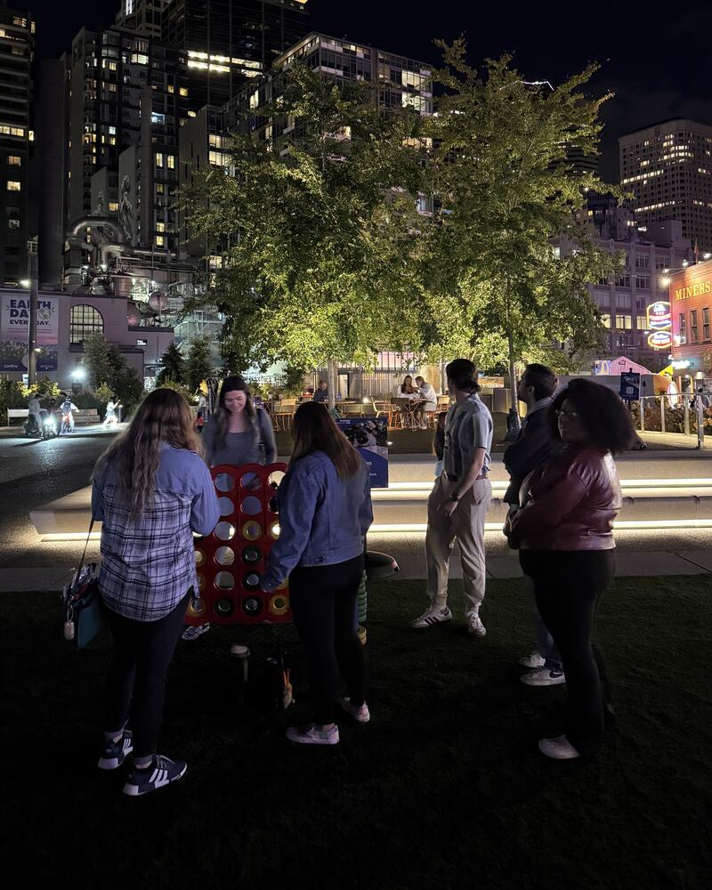 Edge Marketing Agency team members playing lawn games at a downtown Seattle park in the evening