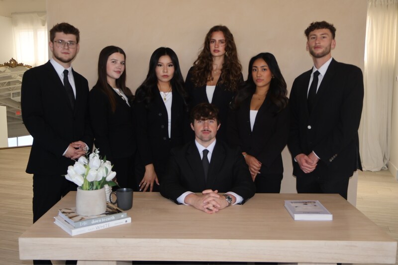 The Edge Marketing Agency sales team in business attire gathered around a table at the office