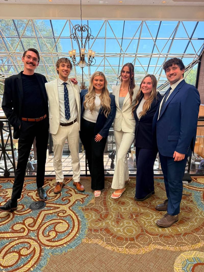 Six Edge Marketing Agency team members in business attire at a company event